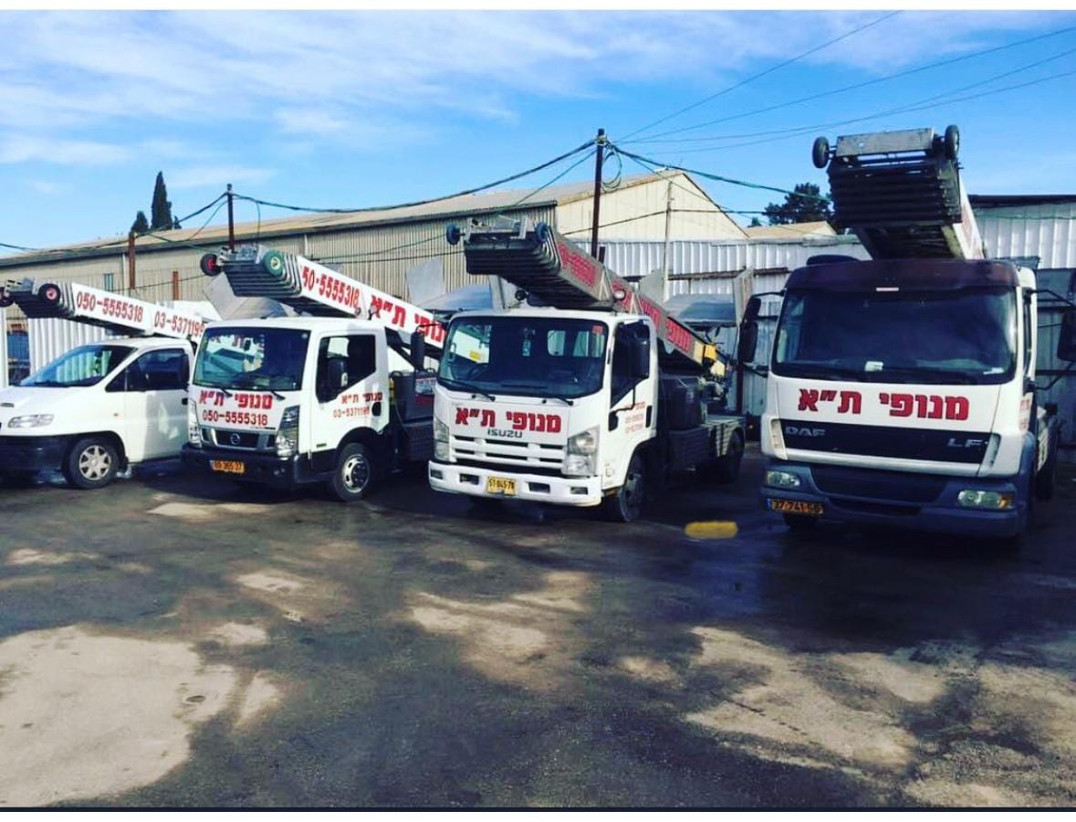 ארבע משאיות מנוף סולם ממותגות מנופי ת"א ורכב שירות עומדים בשורה בחצר החברה